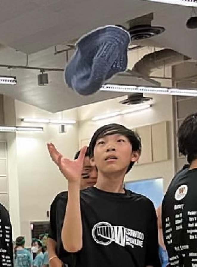 pictured: Bernie Qu, age 14, tossing a blue crocheted hat.