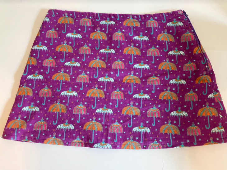 pictured: a purple miniskirt with umbrellas of various patterns on top.
